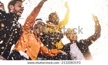 Group of friends enjoying party throwing confetti in the air - Multicultural young students having fun celebrating and laughing out loud outdoor - Youth, friendship and summertime concept Royalty-Free Stock Photo #2132083193