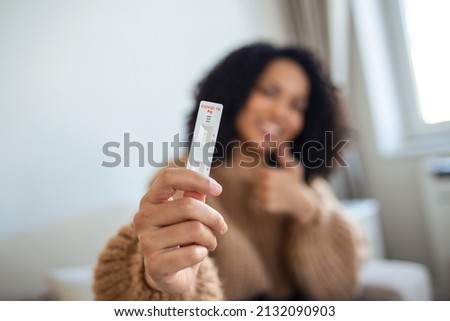 Close-up shot of African-American woman's hand holding a negative test device. Happy young woman showing her negative Coronavirus - Covid-19 rapid test. Focus is on the test.Coronavirus Royalty-Free Stock Photo #2132090903
