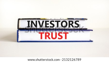 Investors trust symbol. Concept words Investors trust on books on a beautiful white table white background. Business invest and investors trust concept, copy space. Royalty-Free Stock Photo #2132126789