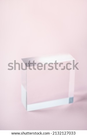 Acrylic Solid Display Block for Shop Windows on pink background, empty podium for product presentation, geometric stand for cosmetics