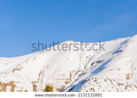 This landscape photo was taken in Europe, in France, Rhone Alpes, in Savoie, in the Alps, in winter. We see Mont Joly, under the Sun.