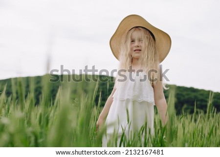 Ukrainian beautiful 7 year old girl in a wheat field. Girl with white hair like an angel.