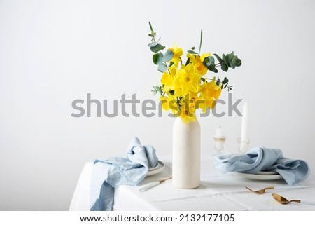 Concept of romanitic Easter table with flowers and white tablecloth, selective focus image