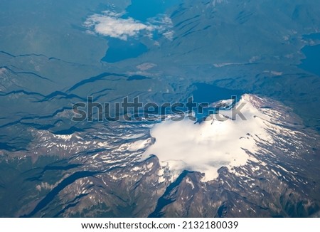 Dramatic aerial view of snow capped volcanos in the Andes mountains of the Patagonia, Chile