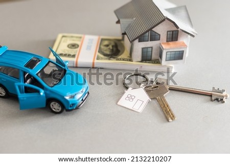 car and house model for sale with money, key on background, house for sale concept, closeup.