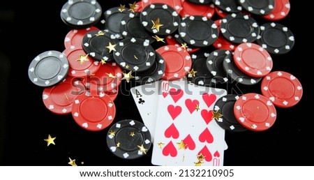 Image of moving stars over poker chips and cards on black background. hazard and casino concept digitally generated image. Royalty-Free Stock Photo #2132210905