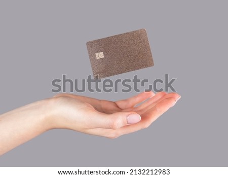 Woman hand and levitating plastic bank or debit card. Cashless payment and booking, making purchases on credit. High quality photo