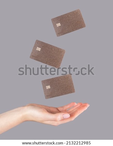 Woman hand and levitating plastic debit cards. Online shopping, booking, performing bank transactions concept. High quality photo