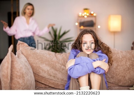 Conflict between mother and child. Woman screams at teenage girl. Sad child feels resentment and hopelessness. Abuse Royalty-Free Stock Photo #2132220623