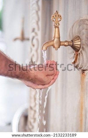 A Muslim man makes a small ablution on the street at the mosque. Turkey. Antalya. Royalty-Free Stock Photo #2132233189