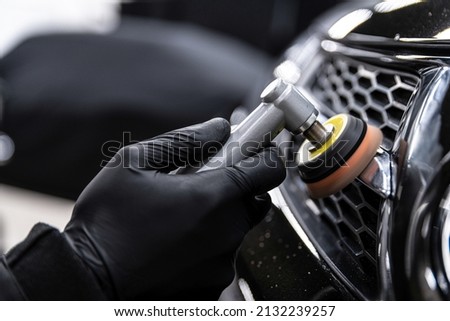 Car detailing technician polishing chrome shine decor on car Royalty-Free Stock Photo #2132239257