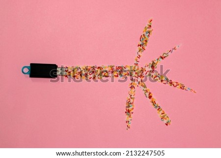 flash drive from which colorful decorative sugar comes out creatively shown the release of information that then branches like a palm tree on a pink background