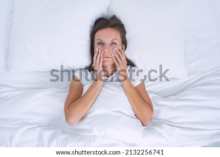 Tired sleepy woman with chronic fatigue or depression lying in the bed. Bad morning Royalty-Free Stock Photo #2132256741