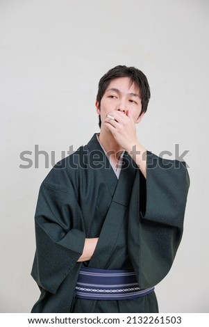 Japanese man in a kimono smoking a cigarette