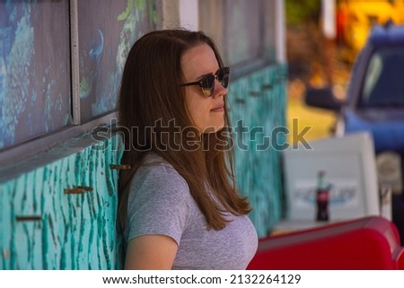 Young woman relaxes while leaning against a wall - photo shoot on the Florida Keys