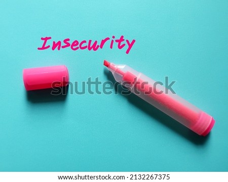 Pink highlight pen write on blue paper INSECURITY, concept of overcome being insecure, or the fear that we are not good enough, and build self-esteem