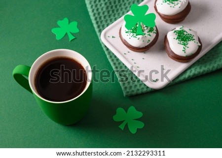 Coffee and three cupcakes for celebration St Patricks Day on green background. Close up.