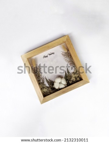 3D frame box containing a gold dowry with dried flowers isolated on a white background