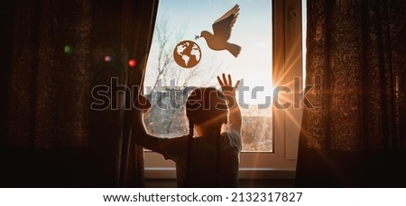 child stretches his hands sunlight sunset outside window flying dove world with branch forces globe. concept peace world, no war, ecology, protection planet Earth, pacifism Royalty-Free Stock Photo #2132317827