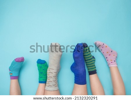 Feet of mothers and children with socks in different colors on a light blue background. Family concept. Support and awareness of people with Down syndrome. March 21. Copy space. Royalty-Free Stock Photo #2132320291