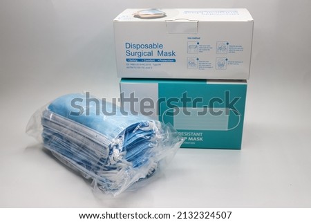 two different box of medical or surgical mask with a pack of blue mask outside on a white background