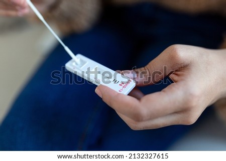 African-American woman using cotton swab while doing coronavirus PCR test at home. Woman using COVID-19 rapid diagnostic test.