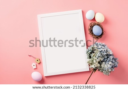 Easter holiday mockup. White frame with easter decorations eggs, hydrangea flat lay on pink background
