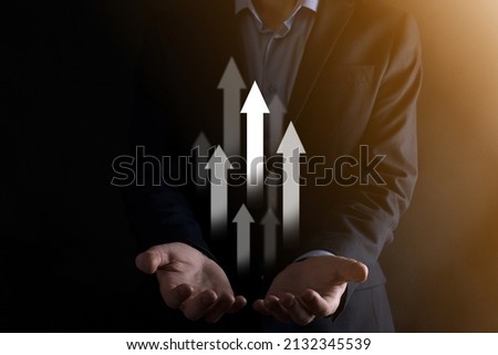Business man holding holographic graphs and stock market statistics gain profits. Concept of growth planning and business strategy. Display of good economy form digital screen. Royalty-Free Stock Photo #2132345539