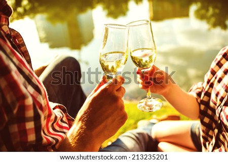 Man and woman clanging wine glasses with champagne
