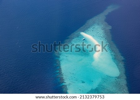 Aerial picture of turquoise blue tropical ocean lagoon, white sandy beach, sandbank coral reef shallow water with a boat. Nature perfection in Maldives sea. Luxury life experience, peaceful landscape