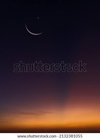 Crescent moon on dusk sky twilight vertical in the evening symbol religion of Islamic well editing text  Ramadan Kareem, Eid Al Fitr, Eid Mubarak, Eid Al Adha on free space background Royalty-Free Stock Photo #2132381055
