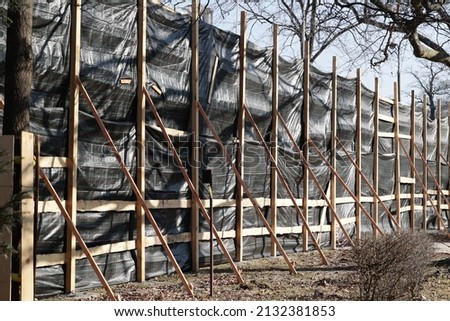 Wooden protection of construction works during the demolition of a dilapidated residential building.