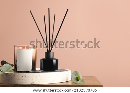 Composition with aromatic reed air freshener on wooden table near pink wall, space for text Royalty-Free Stock Photo #2132398785