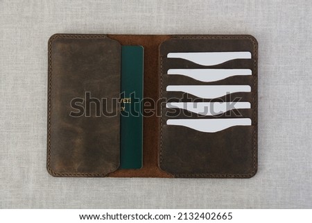 Handmade leather wallets of different colors. (Cream, brown and light brown.) Women's and men's leather accessories.