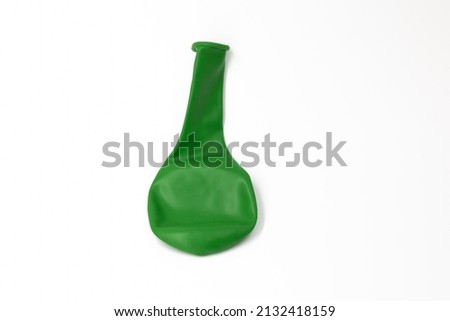 One dark green inflatable uninflated colored balloon for the holiday lies on a white background isolated Royalty-Free Stock Photo #2132418159