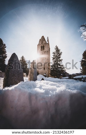 A beautiful view of an old tower in a snowy field