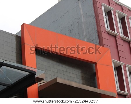 The building has a minimalist nuance, a combination of red and gray. Architecture photography.