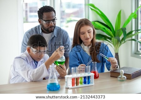 Students mixes chemicals in beakers. enthusiastic teacher explains chemistry to children, chemistry student showing new experiment to teacher science class Royalty-Free Stock Photo #2132443373