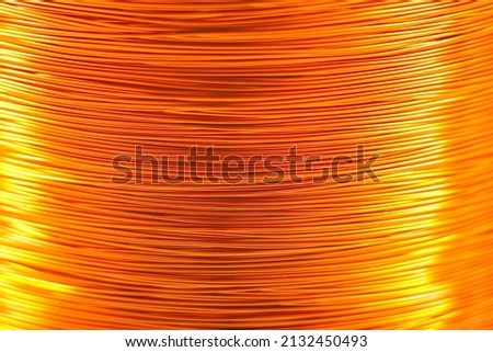 Copper wire for electronics close-up with a focus on the center and blurred edges of the right and left. Designed for the production of electronic components in the electrical industry.