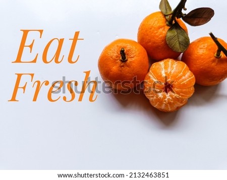 Orange fruits on white background with inspirational quote - Eat fresh