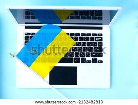 Ukrainian flag and laptop. War in Ukraine, Internet information,  News searching.