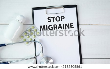 Text on a card Stop Migraine, medical concept.
