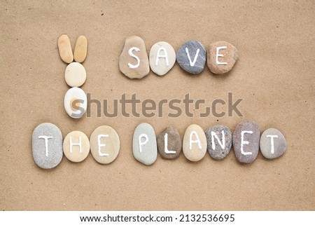 Save the Planet letters and bunny from pebbles on craft paper background. Ecological, eco friendly, zero waste, nature postcard, banner. Animal, World Habitat, Earth Day concept. Flat lay, top view 