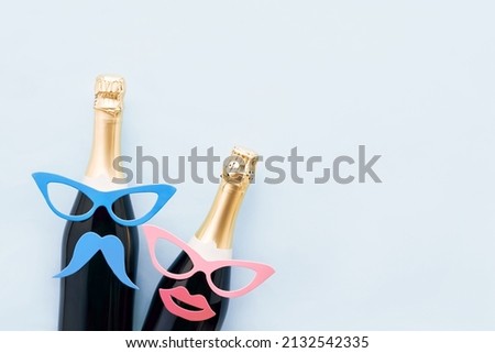 Holiday background with party props, masks, and champagne on a light blue background. Carnival concept, purim background. Top view, copy space