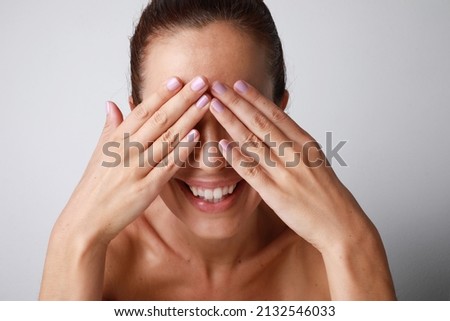 Portrait of happy young woman smiles and touches her face gently. Isolated.