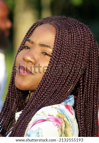 Portrait of a young African woman with dreadlocked pigtails on her head.
