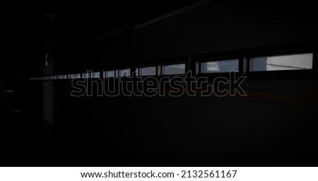 a row of rectangle windows in a black hallway 