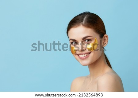 young woman patches rejuvenation skin care fun after shower blue background