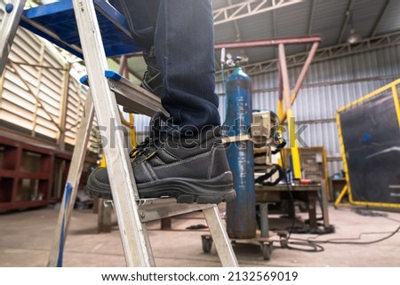 Wear safety shoes to ensure safety at work. construction workers wear safety shoes. concept. Construction workers work on the stairs Royalty-Free Stock Photo #2132569019
