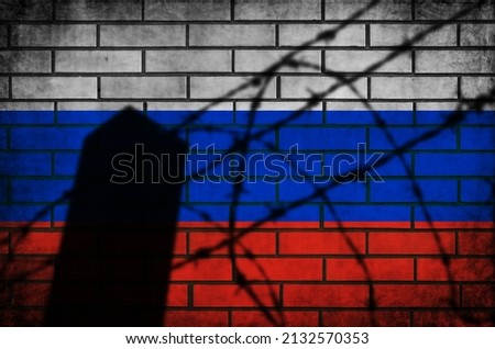 Russian flag with barbed fence. Conflict and war concept. Grunge background texture on brick wall Royalty-Free Stock Photo #2132570353